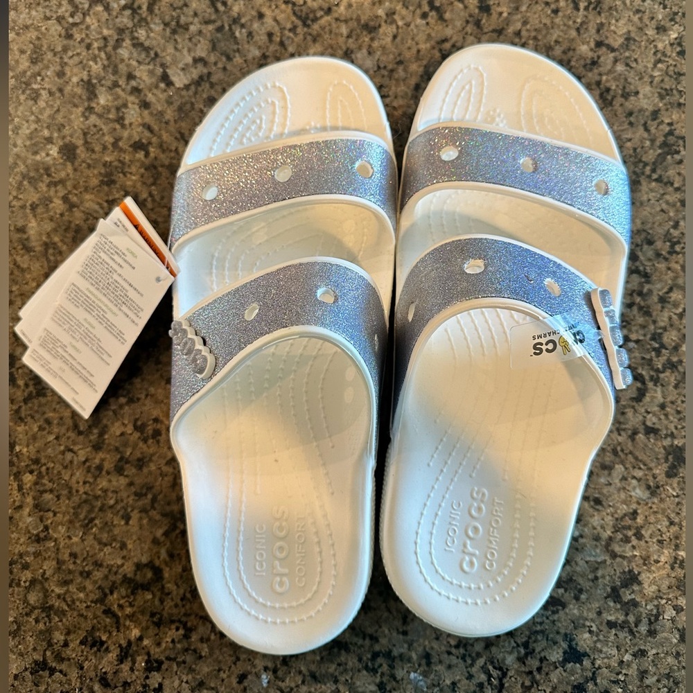 New with tags slip on Crocs. Glitter straps on white sandals. Women’s size 9